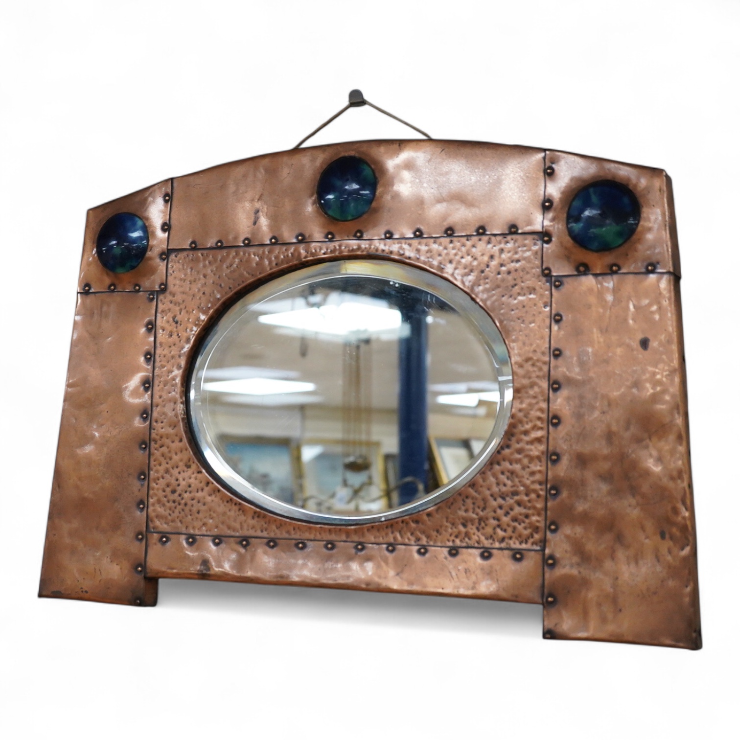 An Arts and Crafts riveted copper and Ruskin pottery cabochon inset mirror, 39cm high
